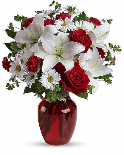 Bouquet of red and white flowers in a red vase on a white background