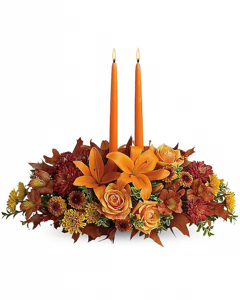 Floral arrangement with orange candles