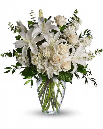 Bouquet of white flowers in a clear vase on a white background