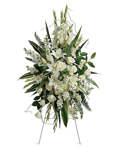 Beautiful floral arrangement of white blooms and green leaves on stand
