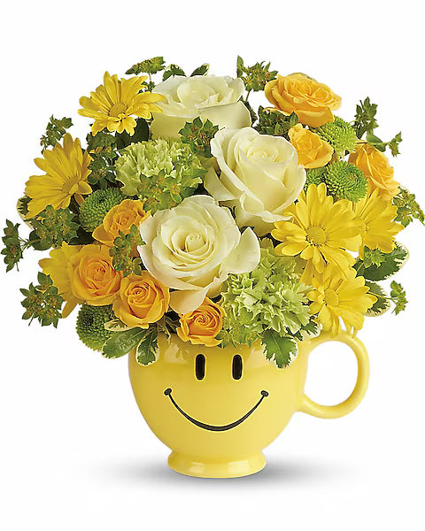 Yellow smiley face mug filled with a bouquet of yellow and white flowers on a white background