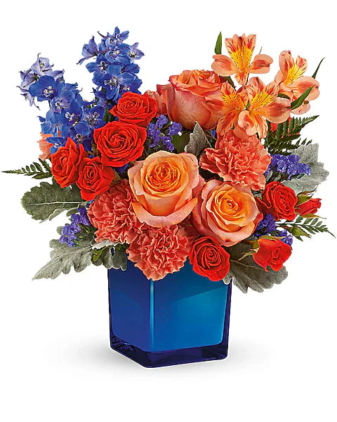 Colorful bouquet of flowers in a blue vase on a white background